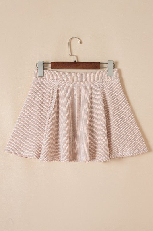 Pink ruffle mini skirt on hanger with gathered waistband and pleated bell silhouette