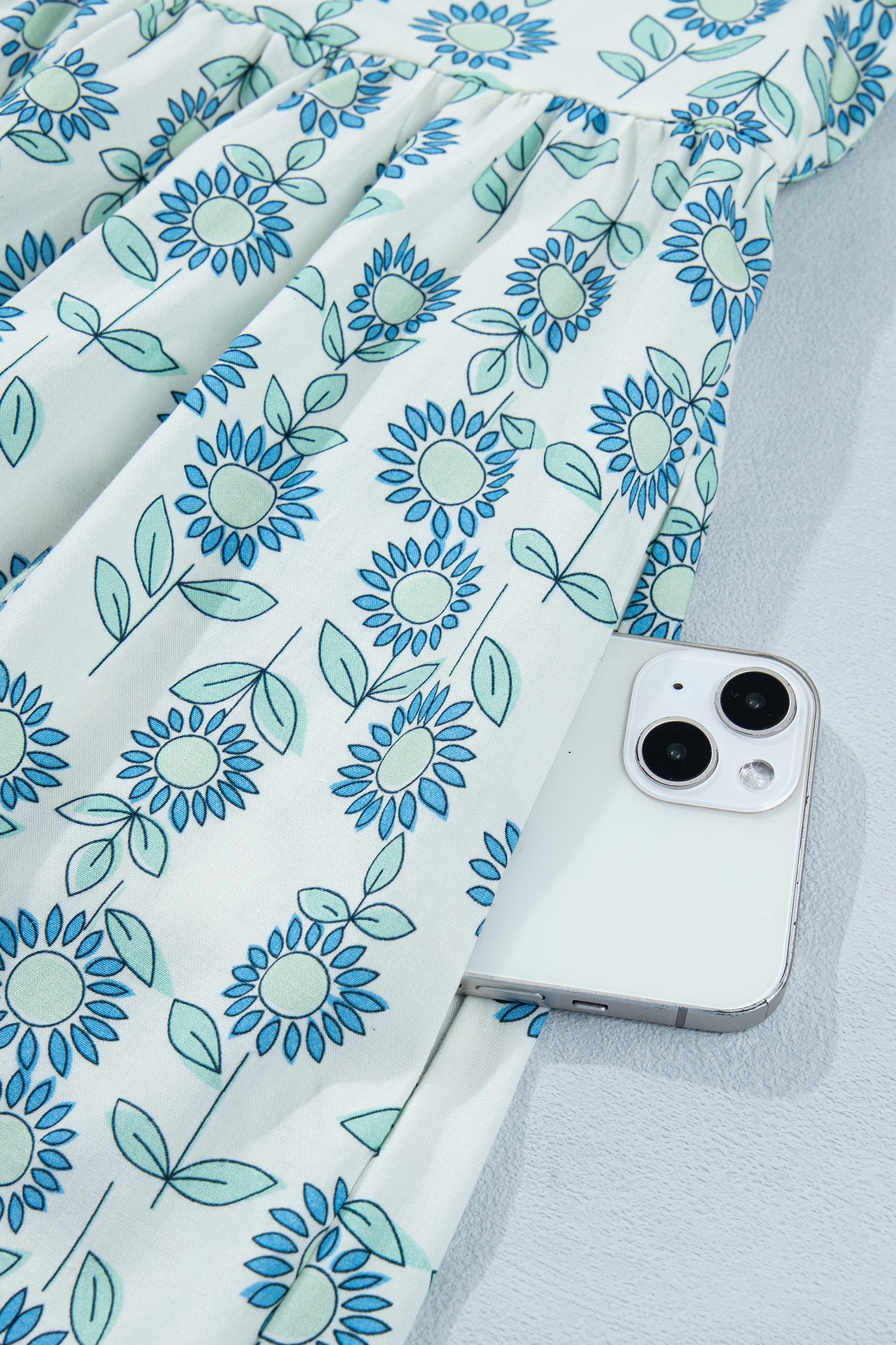Sky blue mini dress with flutter sleeves, round neckline, and blue daisy floral print