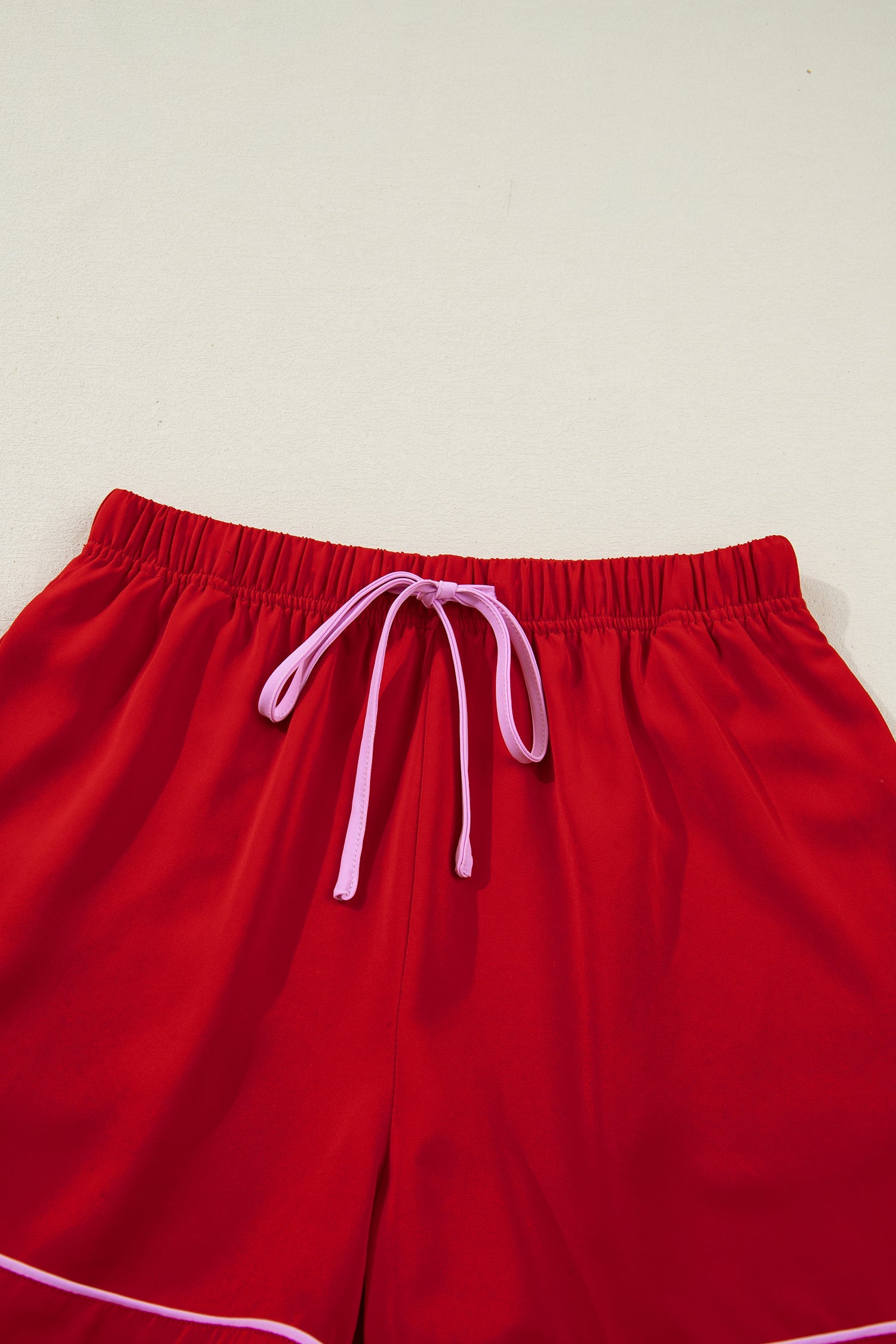 Red pajama shorts with elastic waistband and white drawstring ties