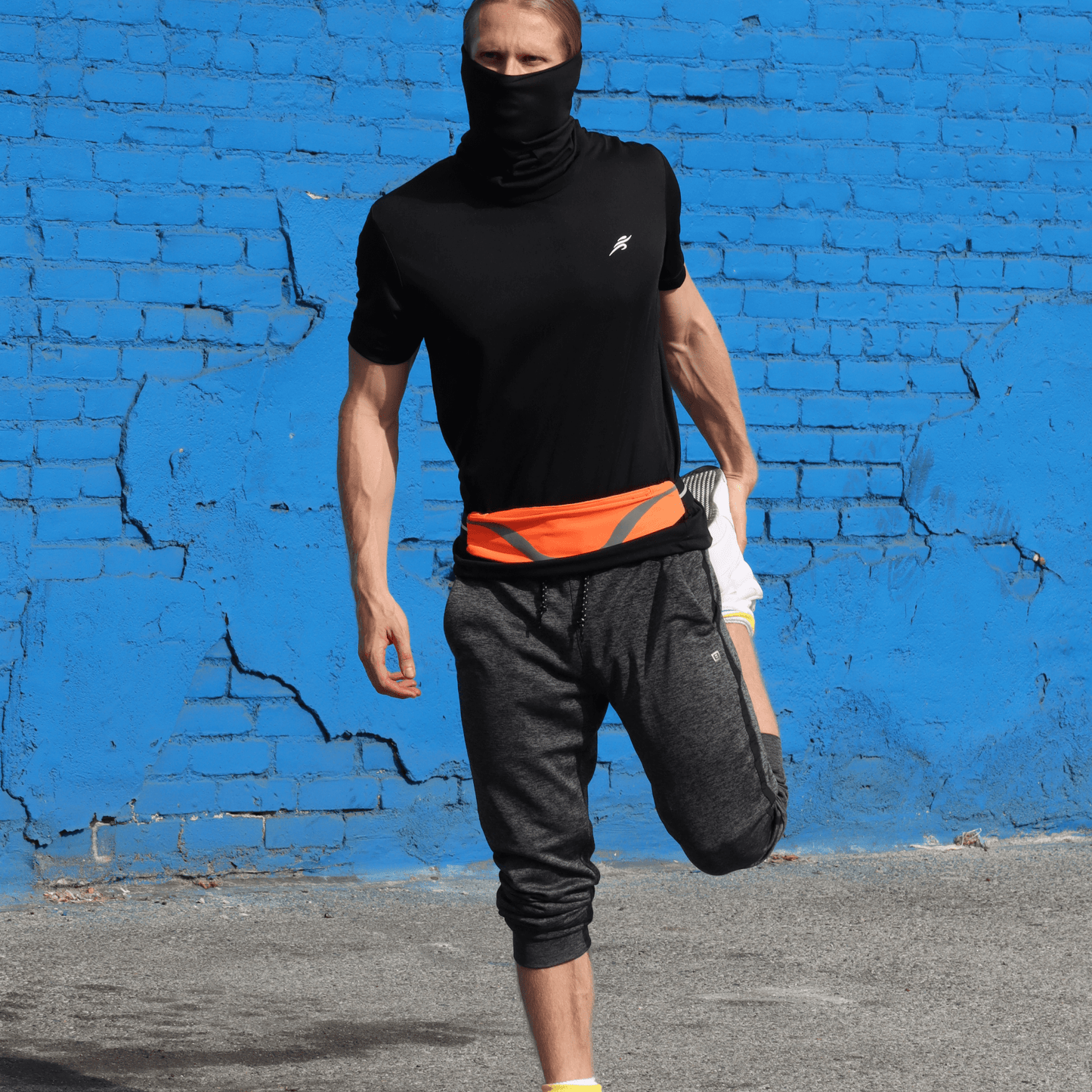 Water-resistant sport waist pack with orange reflective stripe, worn around a runner’s waist.