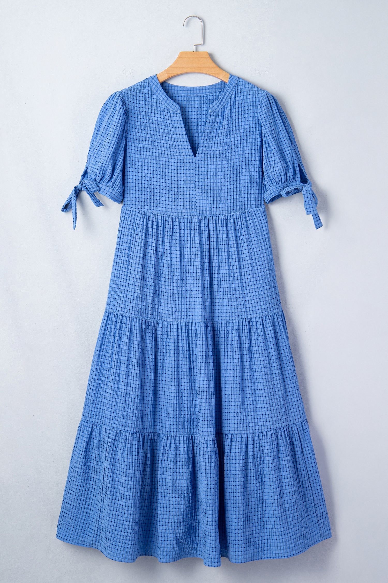 Dusk blue tiered midi dress on hanger with V-neck and tie-cuff sleeves
