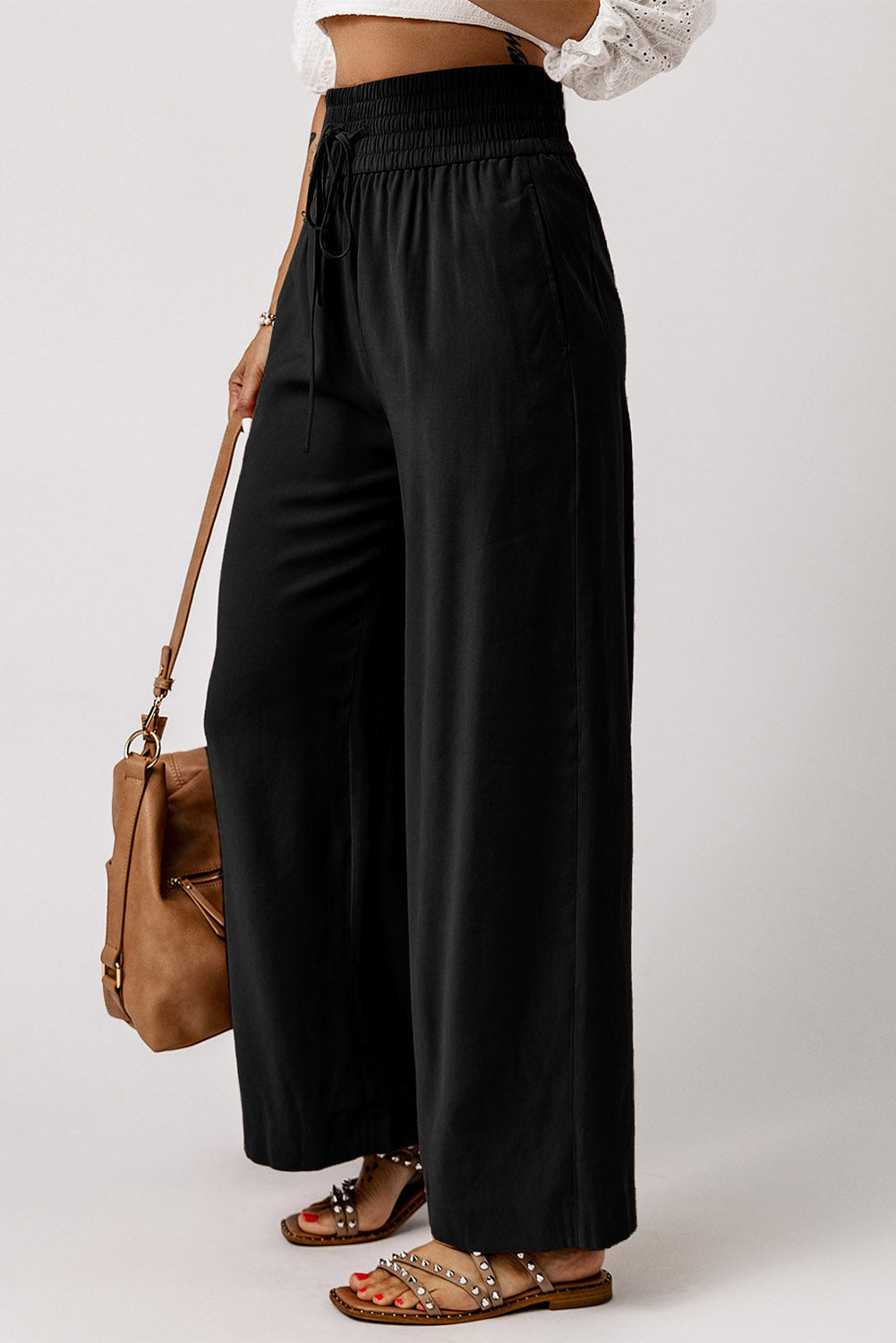 Black wide-leg pants with elastic waist, drawstring, and relaxed drape