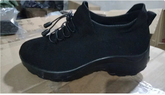 Black lace-up athletic sneaker with textured upper and thick dark sole