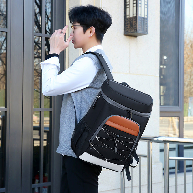 Black insulated insulated backpack with orange front panel, curved top, and adjustable shoulder straps