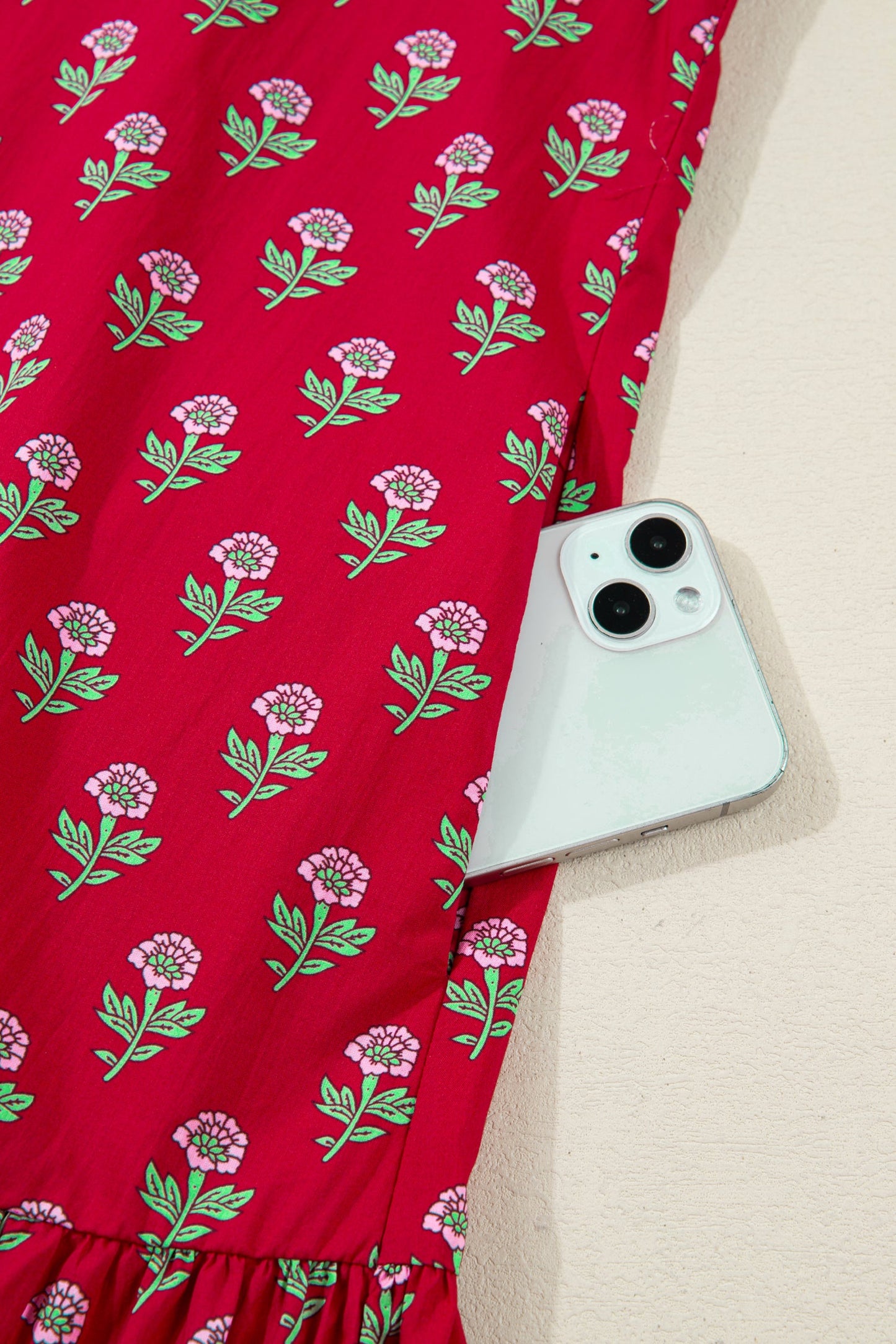 Red mini dress with green floral print and gathered hemline