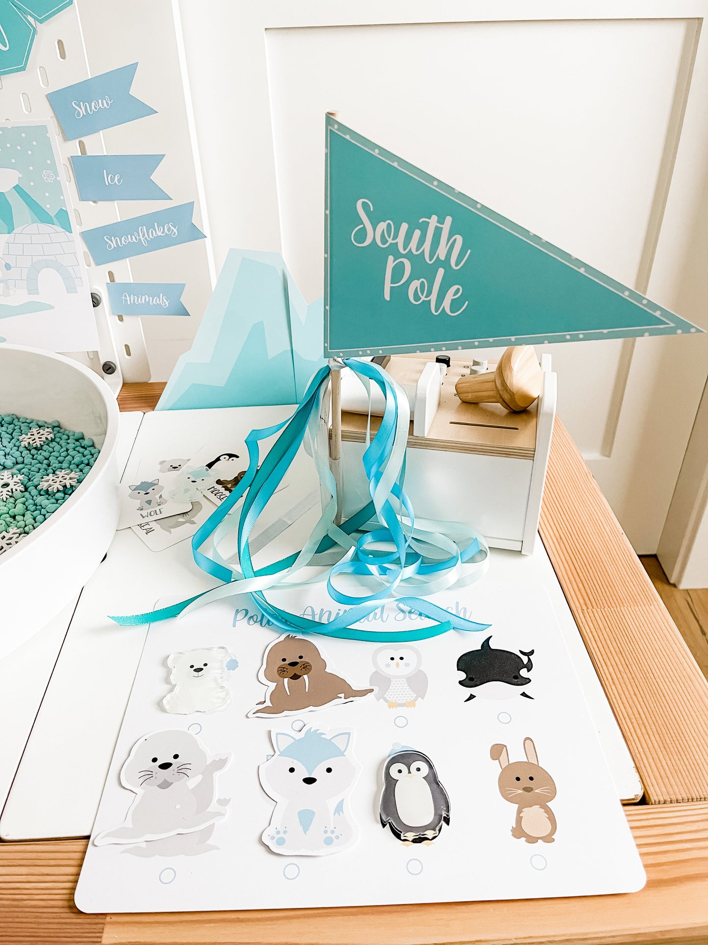 Polar animal sensory play setup with South Pole banner and polar animal stickers