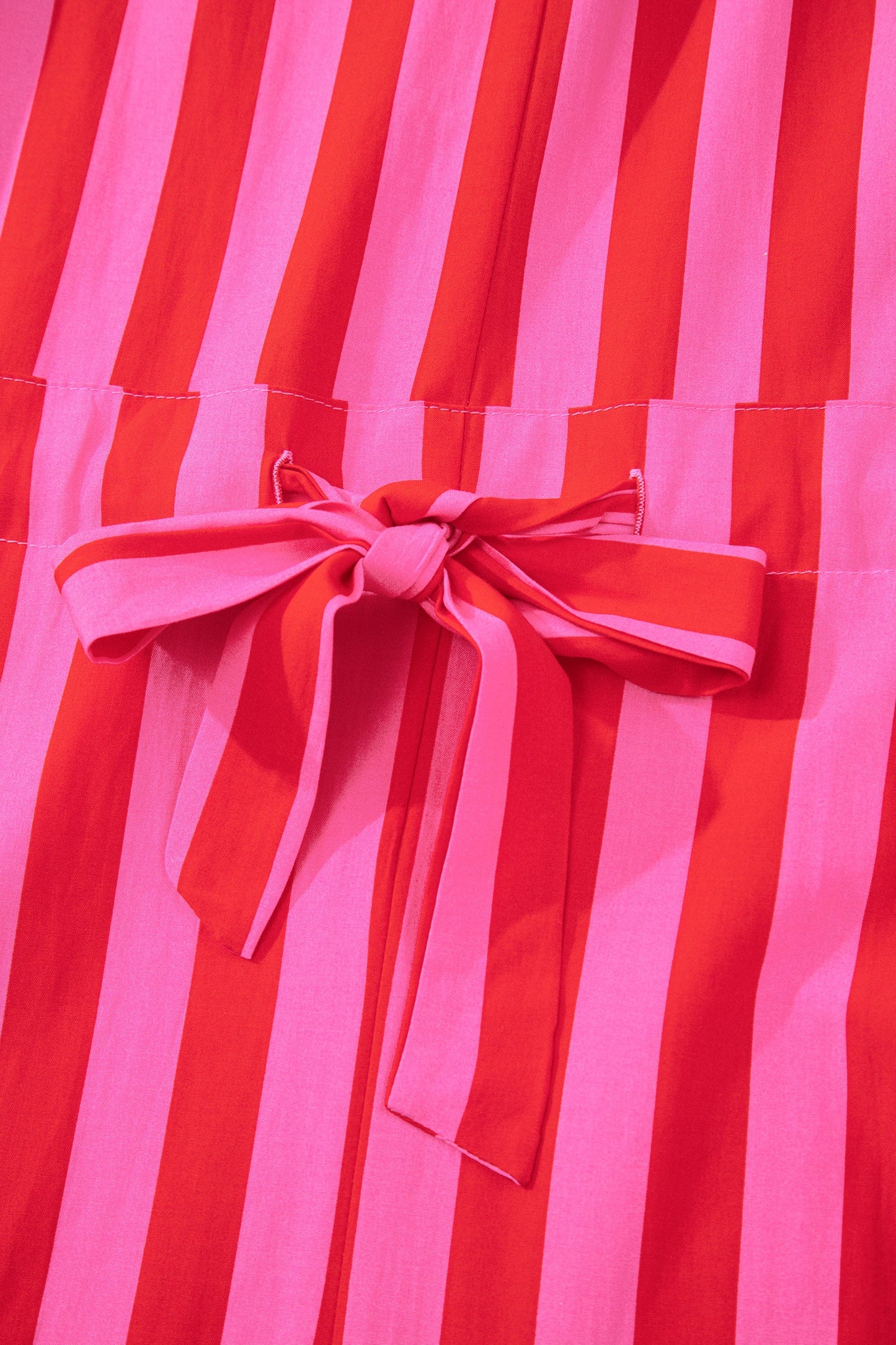 Close-up of pink bow tie on pink and red striped dress