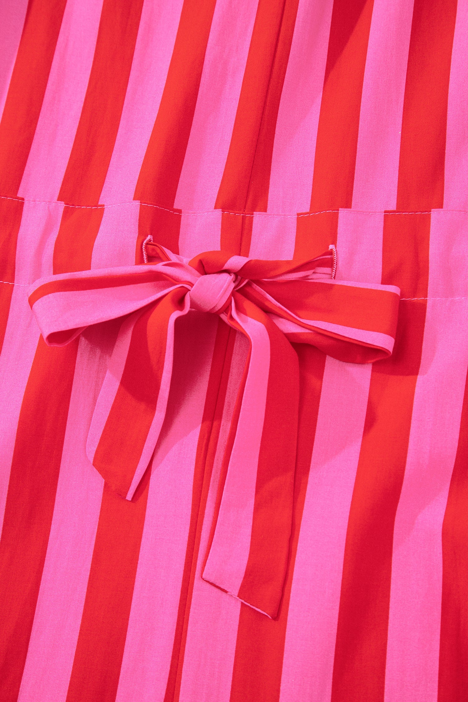 Close-up of pink bow tie on pink and red striped dress