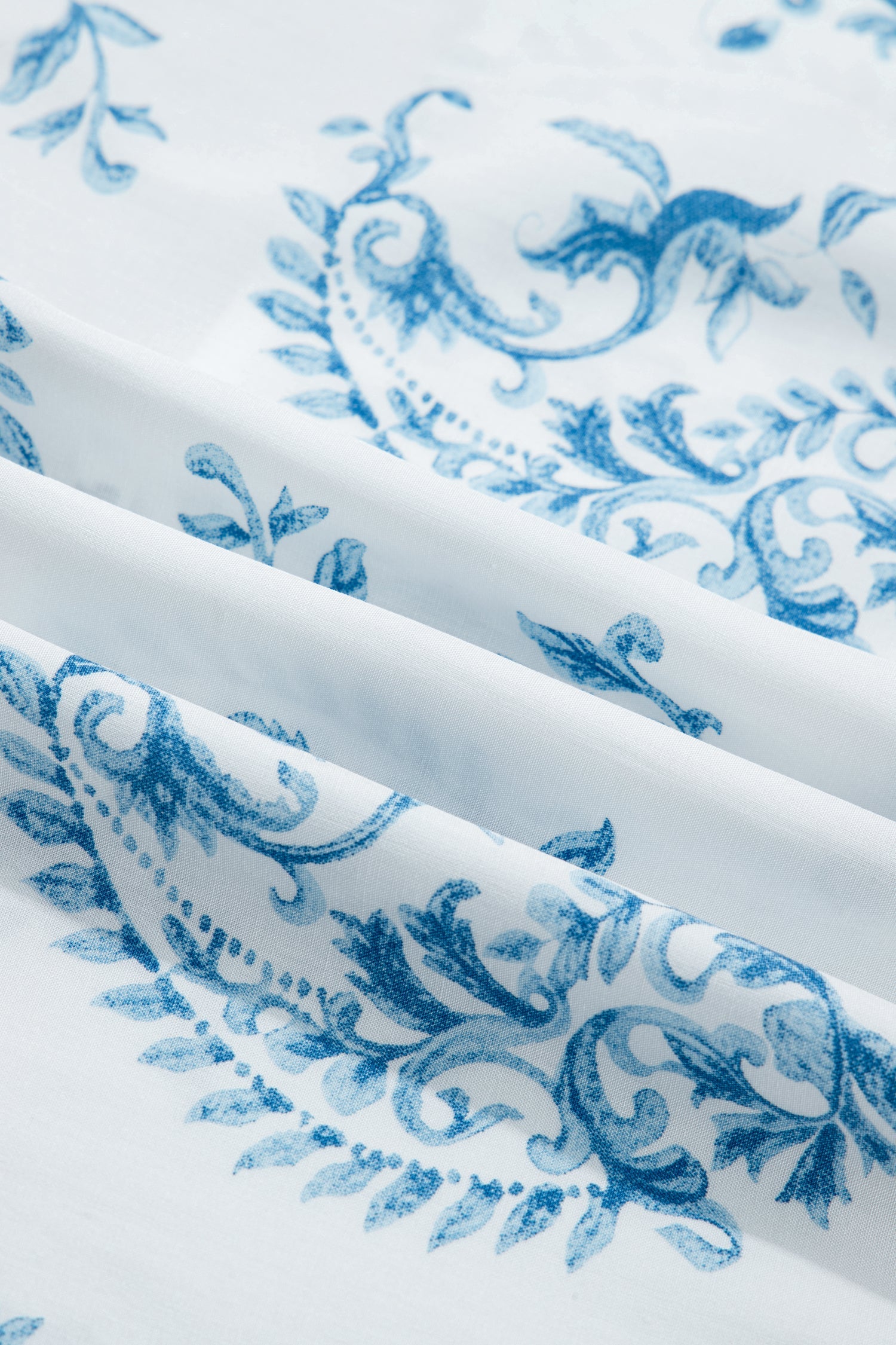 Sky blue floral print fabric with smooth drape across gathered folds