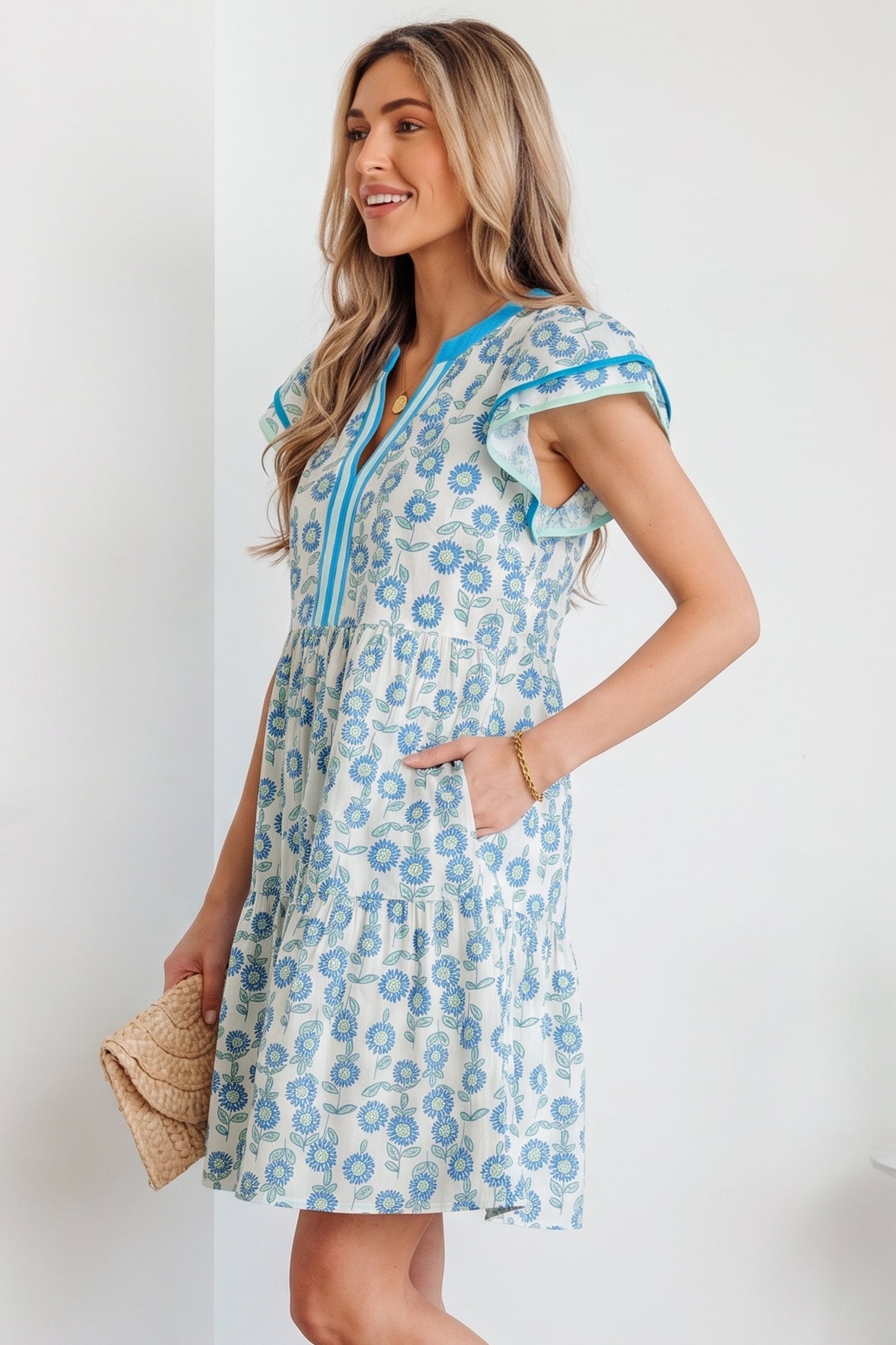 Sky blue mini dress with flutter sleeves, blue-trim V placket, and floral print