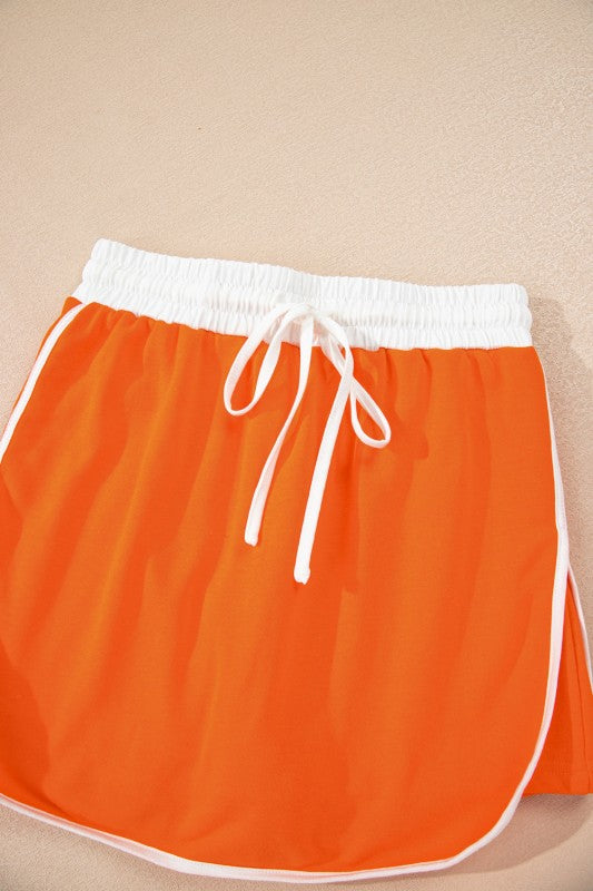 Mini skirt in orange with white drawstring waistband and gathered top