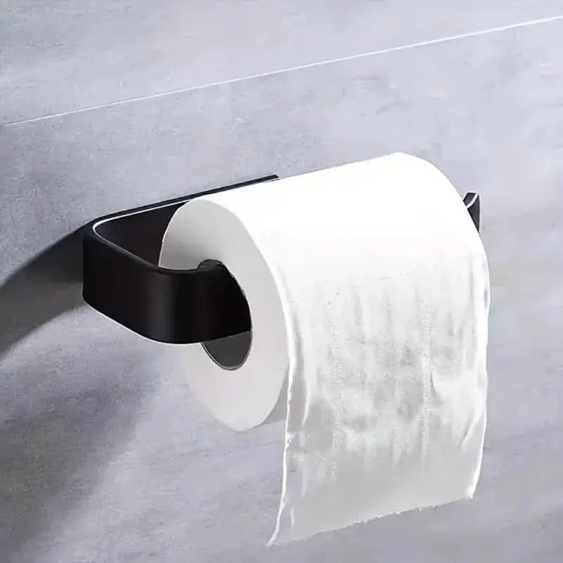 Black toilet paper holder attached to wall holding a white paper roll