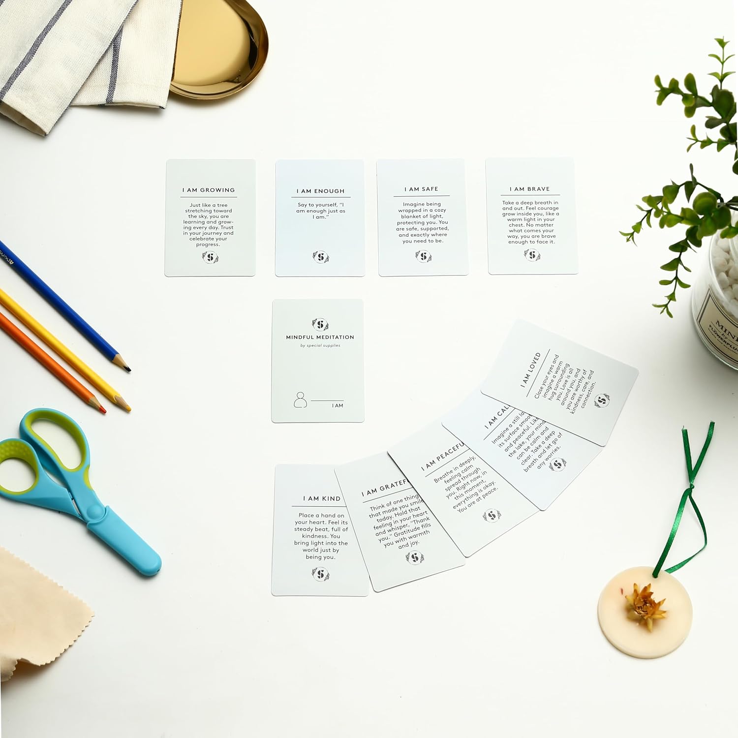 Mindfulness affirmation cards spread on table, front cards with printed text and icons.