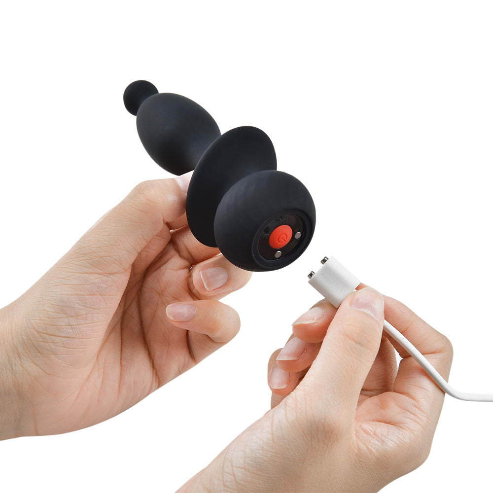 Black silicone bunny plug with orange power button and charging cable