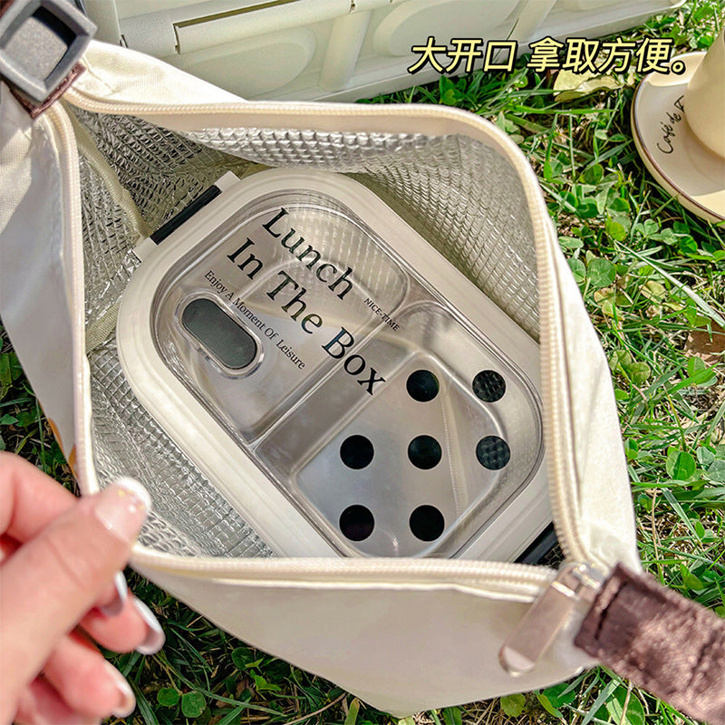 Insulated lunch bag open with mesh lining and a clear-lid food container inside