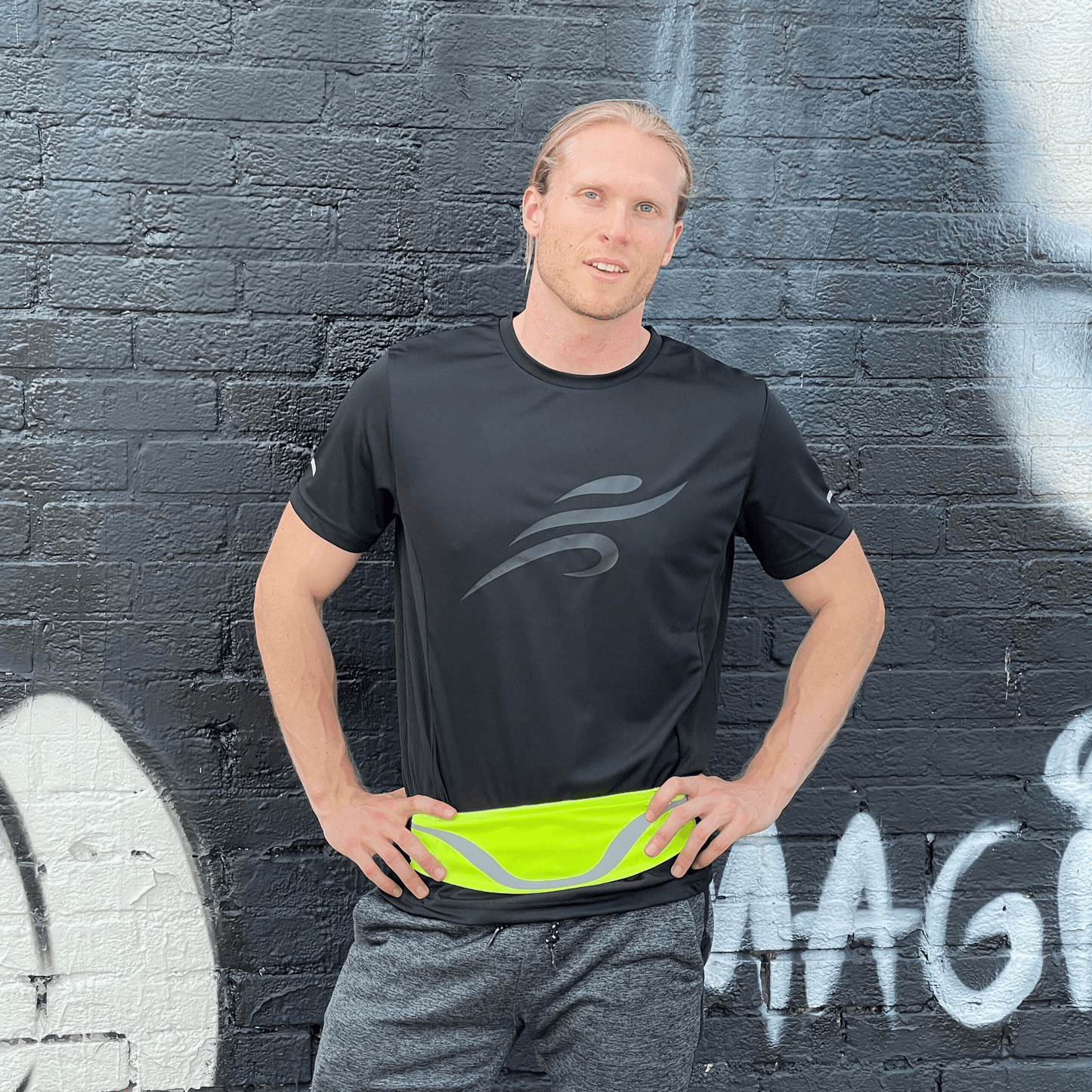Water-resistant sport waist pack running belt with neon green reflective stripe, worn at waist.