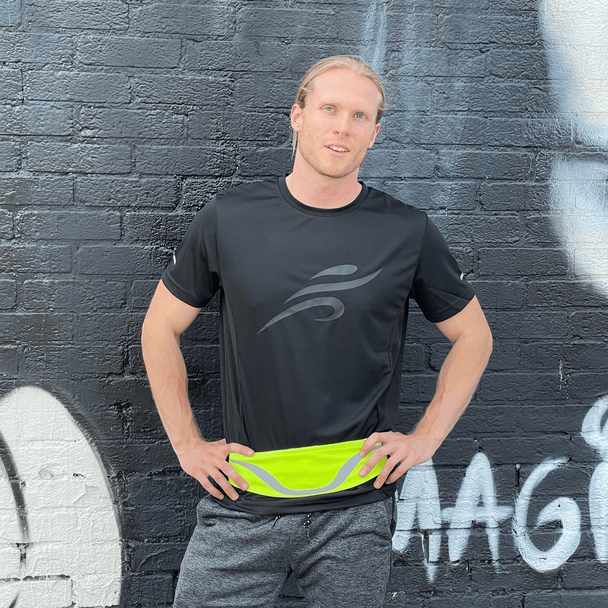 Water-resistant sport waist pack running belt with neon green reflective stripe, worn at waist.