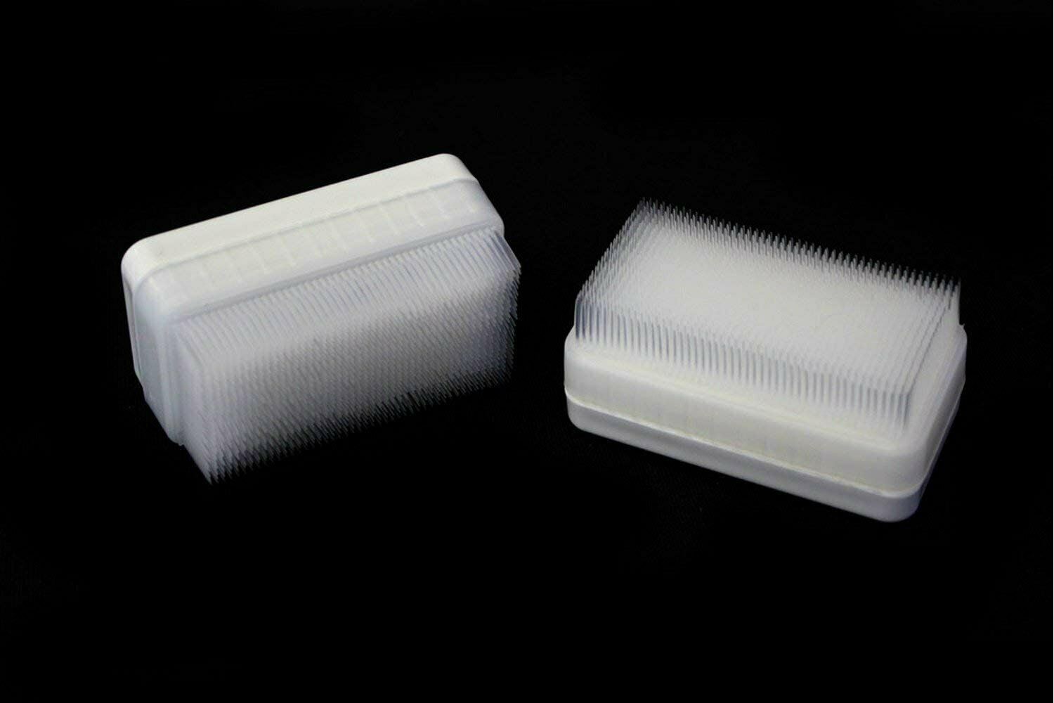 Two compact therapressure brushes with white bristles on clear plastic housings