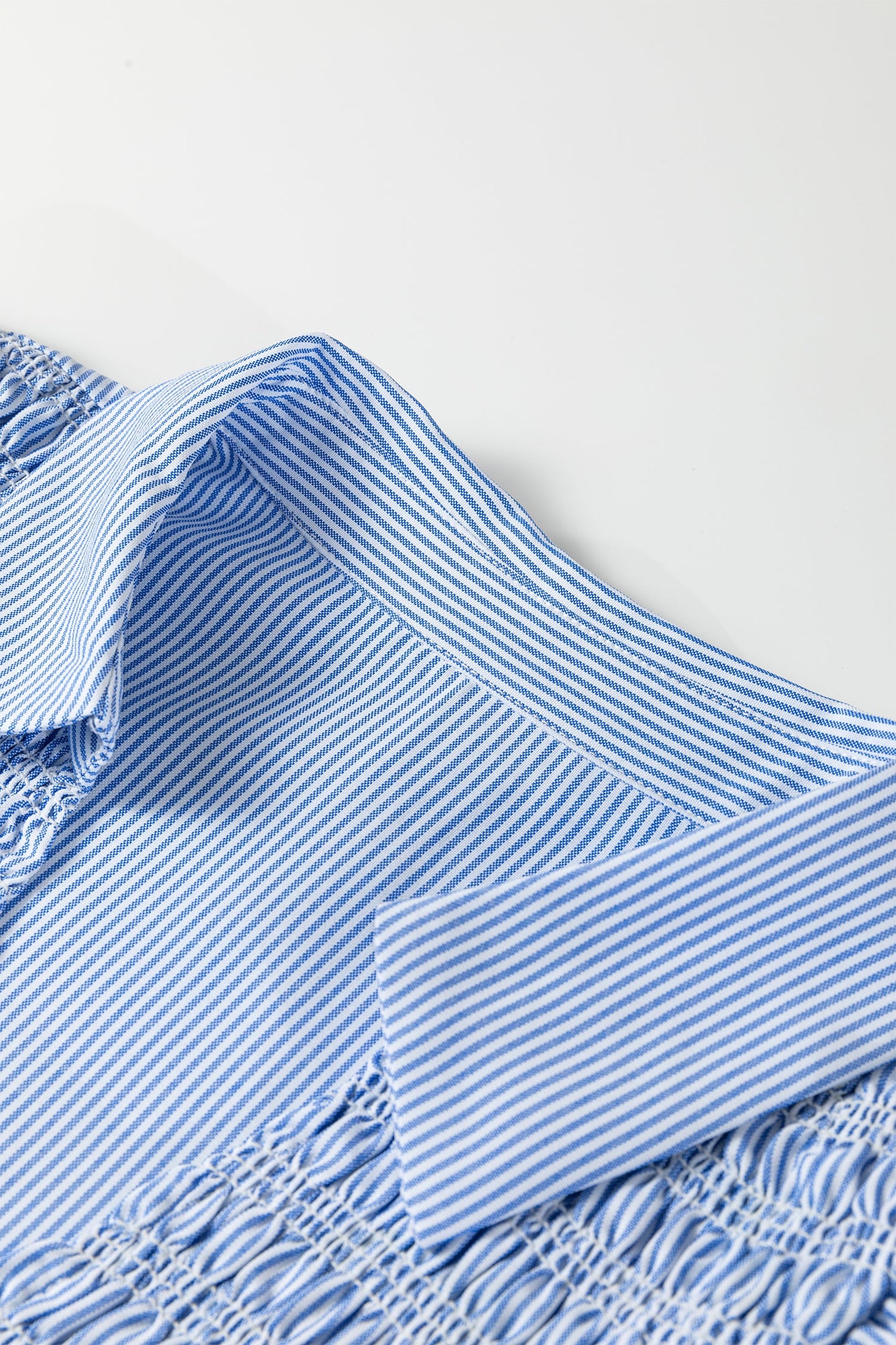 Close-up of sky blue striped V-neck bodice with ruffled detail