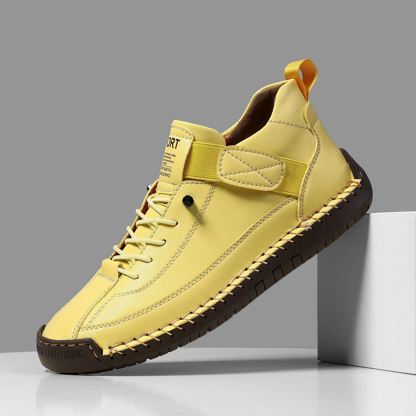 Casual leather boots in yellow with lace-up front, side strap, and dark textured tread sole.