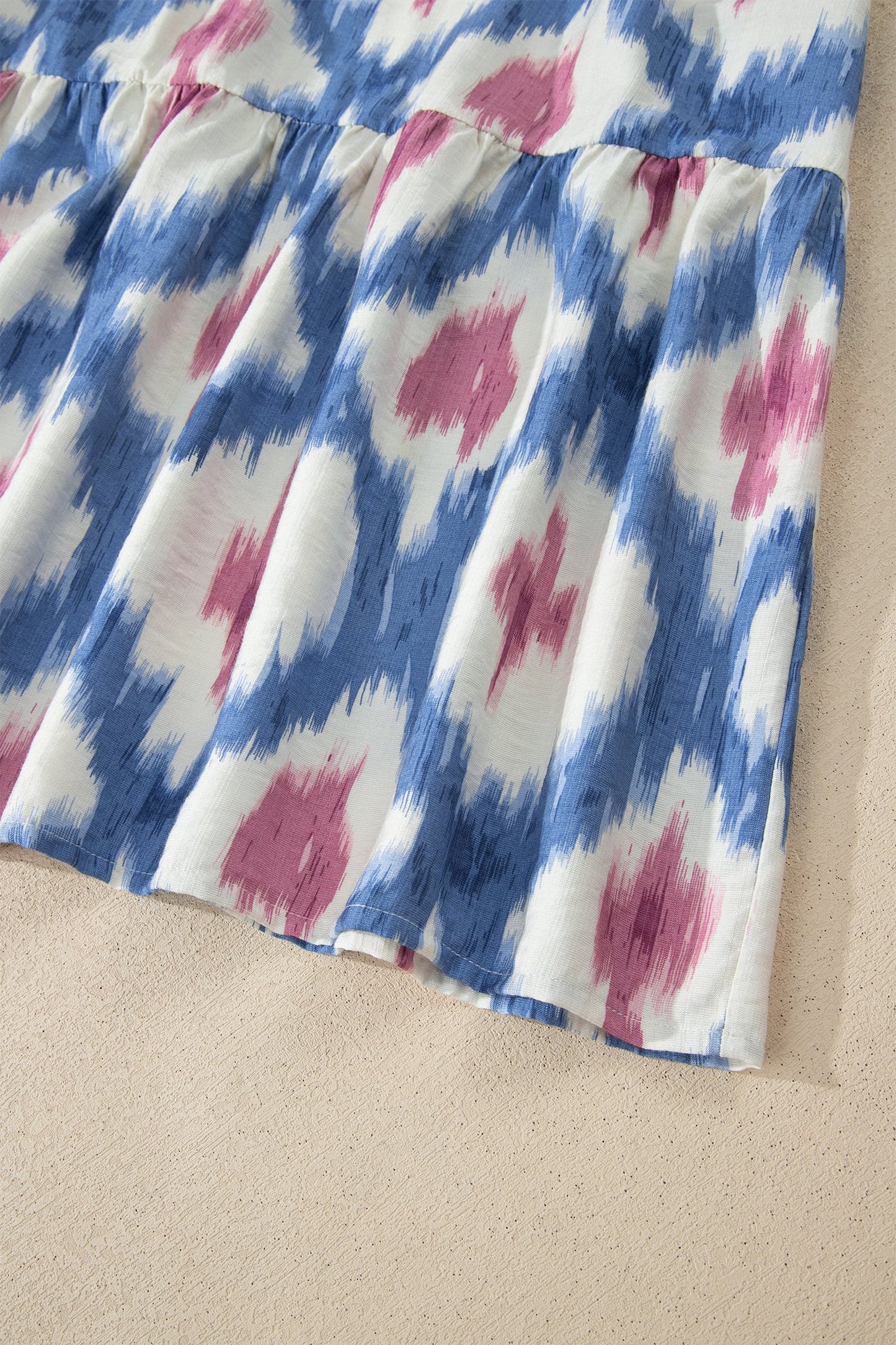 Sky-blue ruffle-sleeve dress with pink abstract print and gathered elastic waist.