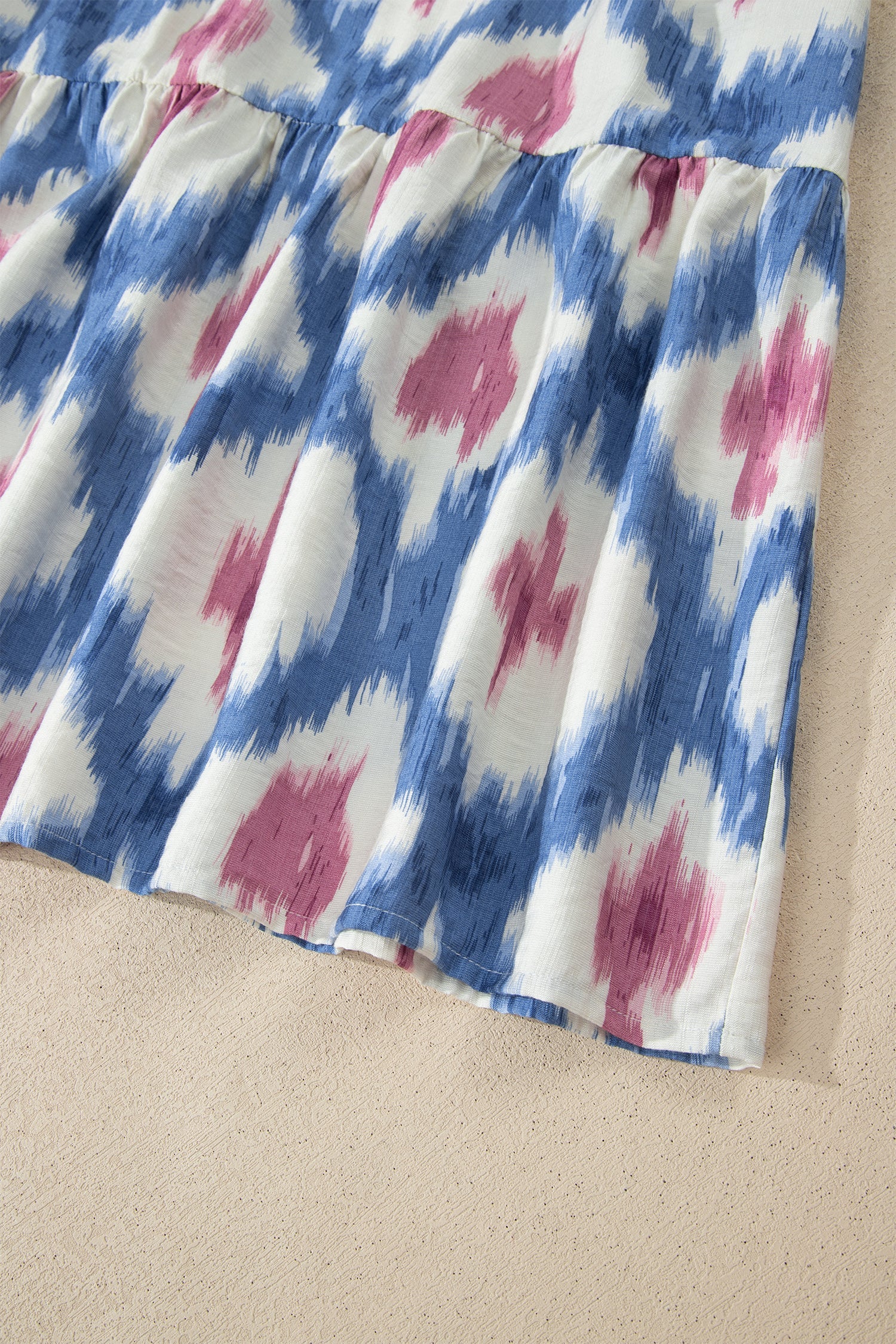 Sky-blue ruffle-sleeve dress with pink abstract print and gathered elastic waist.
