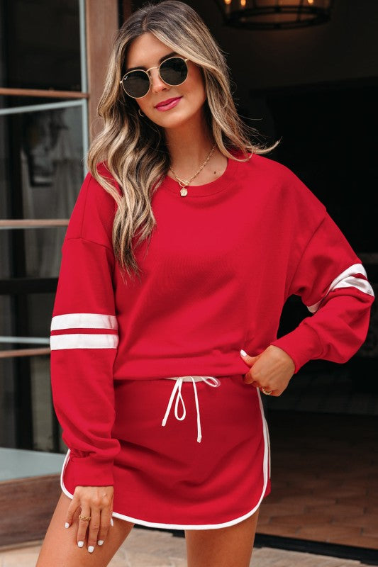 Red sweatshirt and mini skirt set with white striped sleeves and gathered drawstring waist