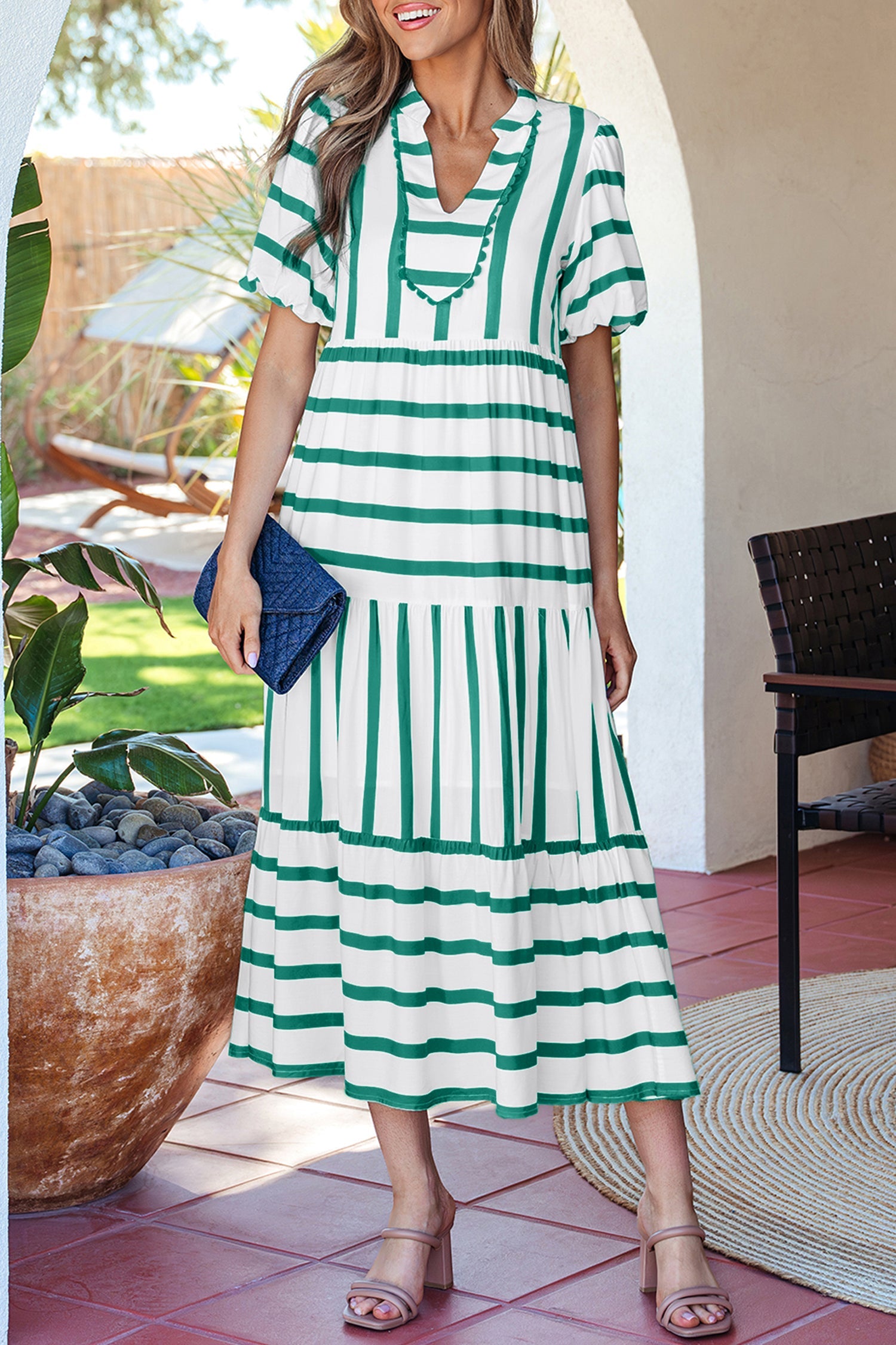 Green and white striped midi dress with half sleeves and tiered skirt, standing