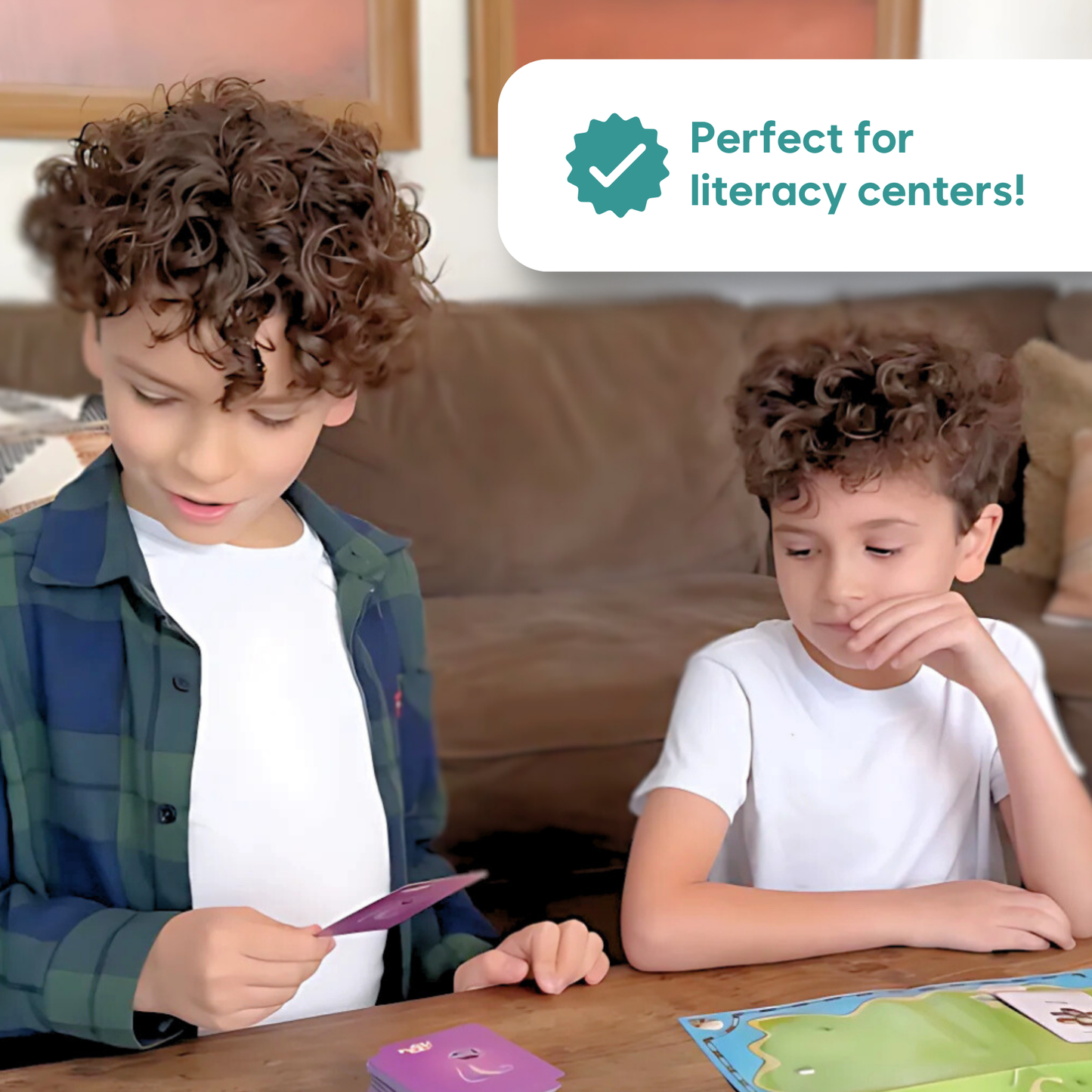 Two children using word cards and an island map board game for literacy practice