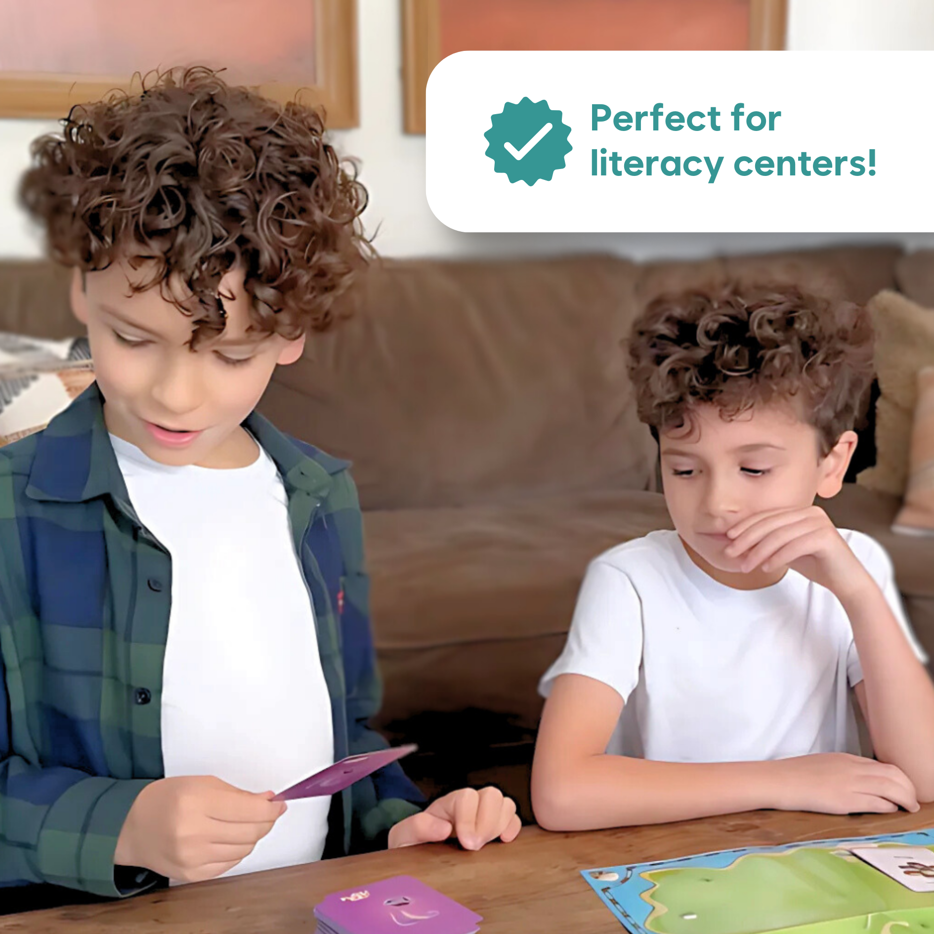 Two children using word cards and an island map board game for literacy practice