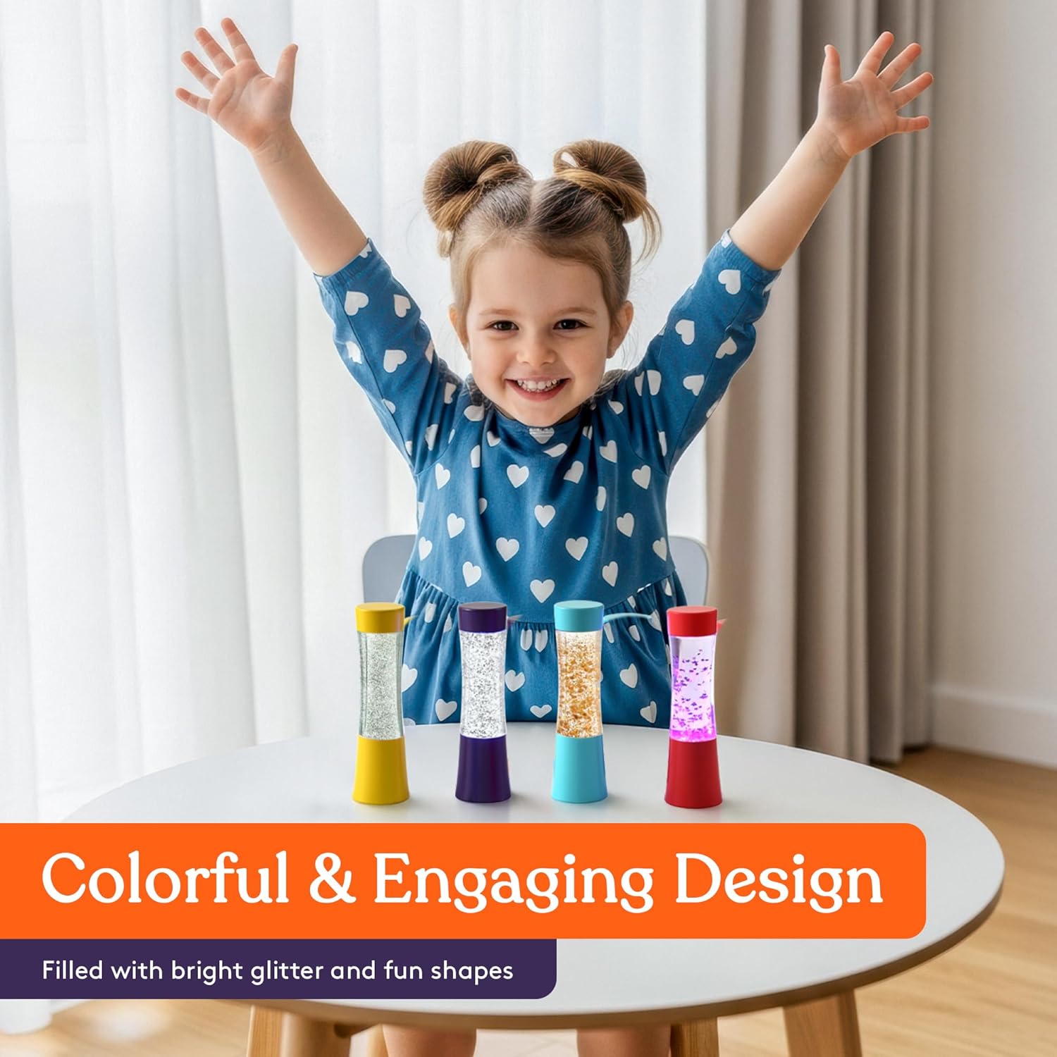 Child standing behind 4 colorful glitter sensory tubes on a round table