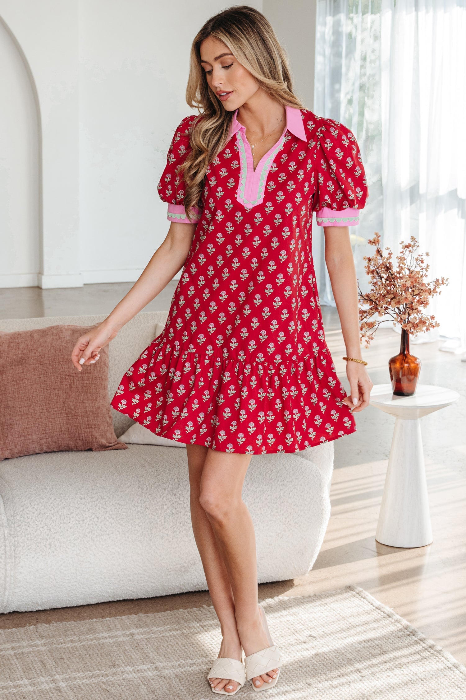 Red mini dress with pink-trim V-neck and bubble sleeves; side view with flared skirt.