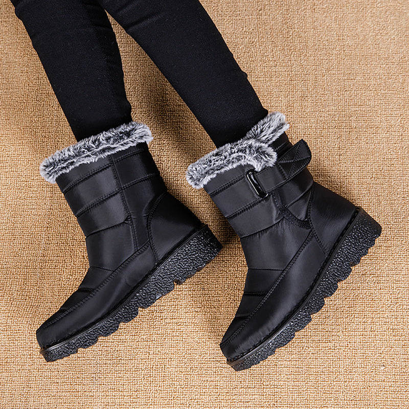 Black snow boots with faux-fur ankle cuff and hook-and-loop buckle, grippy platform outsole