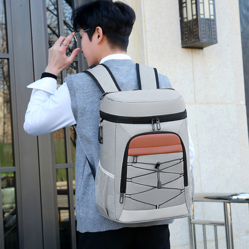 Gray insulated backpack with orange front panel and zippered storage panels with net-style stitching