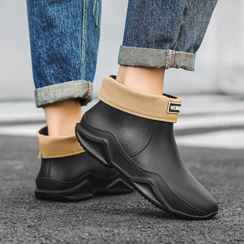 Men's short rain boots in black with thick tread outsole and logo patch