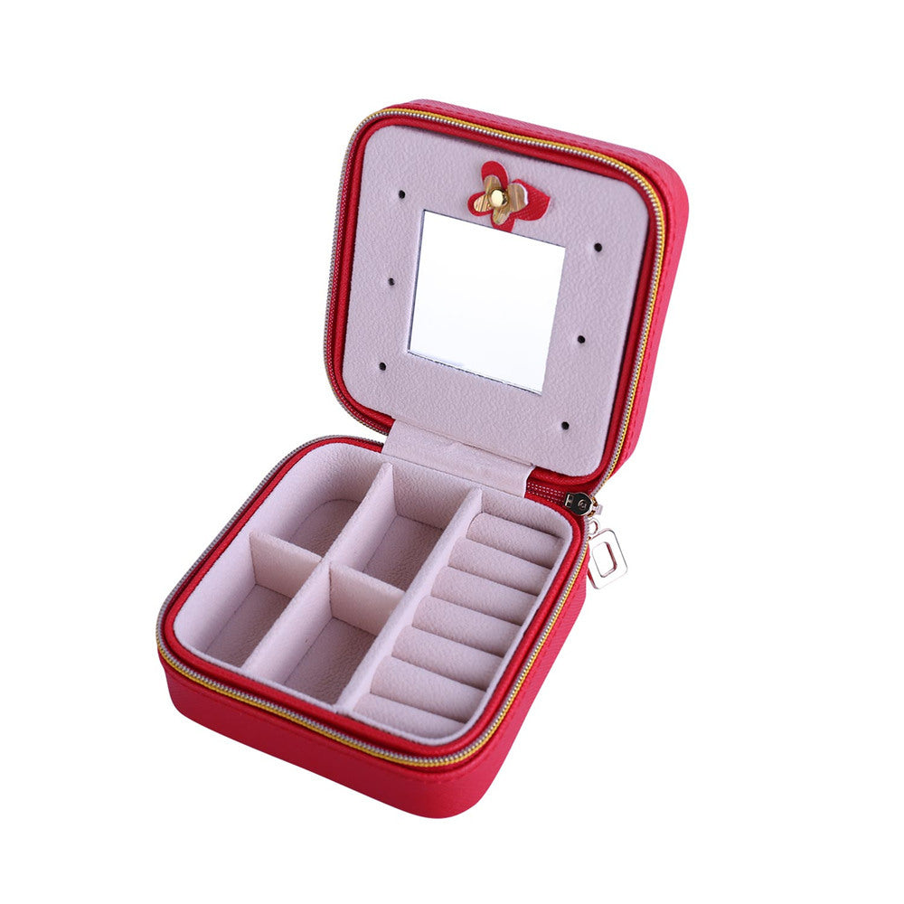 Red jewelry organizer case opened with hinged mirror, zipper, and ring storage sections