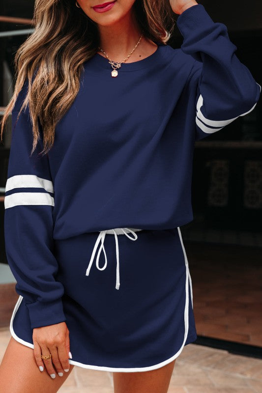 Navy pullover with white stripe cuff and matching drawstring mini skirt hem trim.