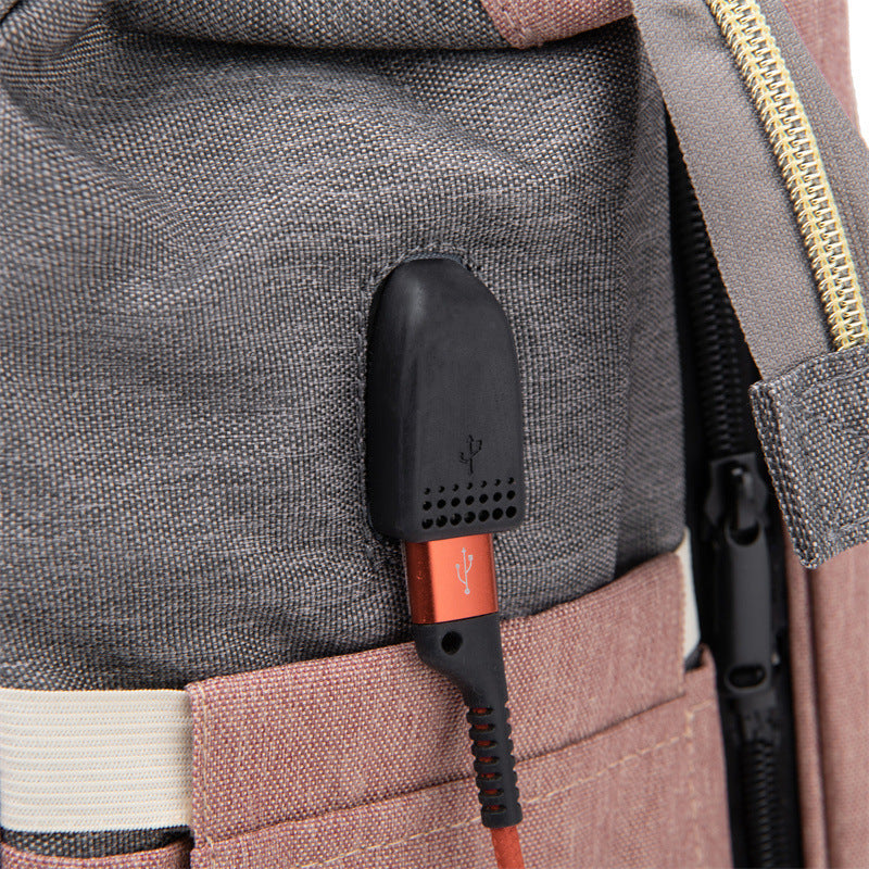 Baby crib backpack strap close-up with black controller and orange label