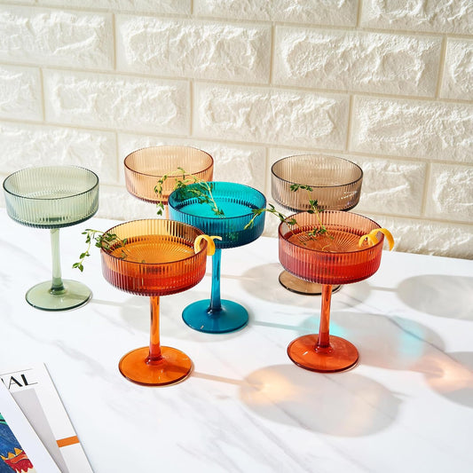 Set of 6 ribbed coupe glasses with fluted bowls in orange, teal, and amber tones