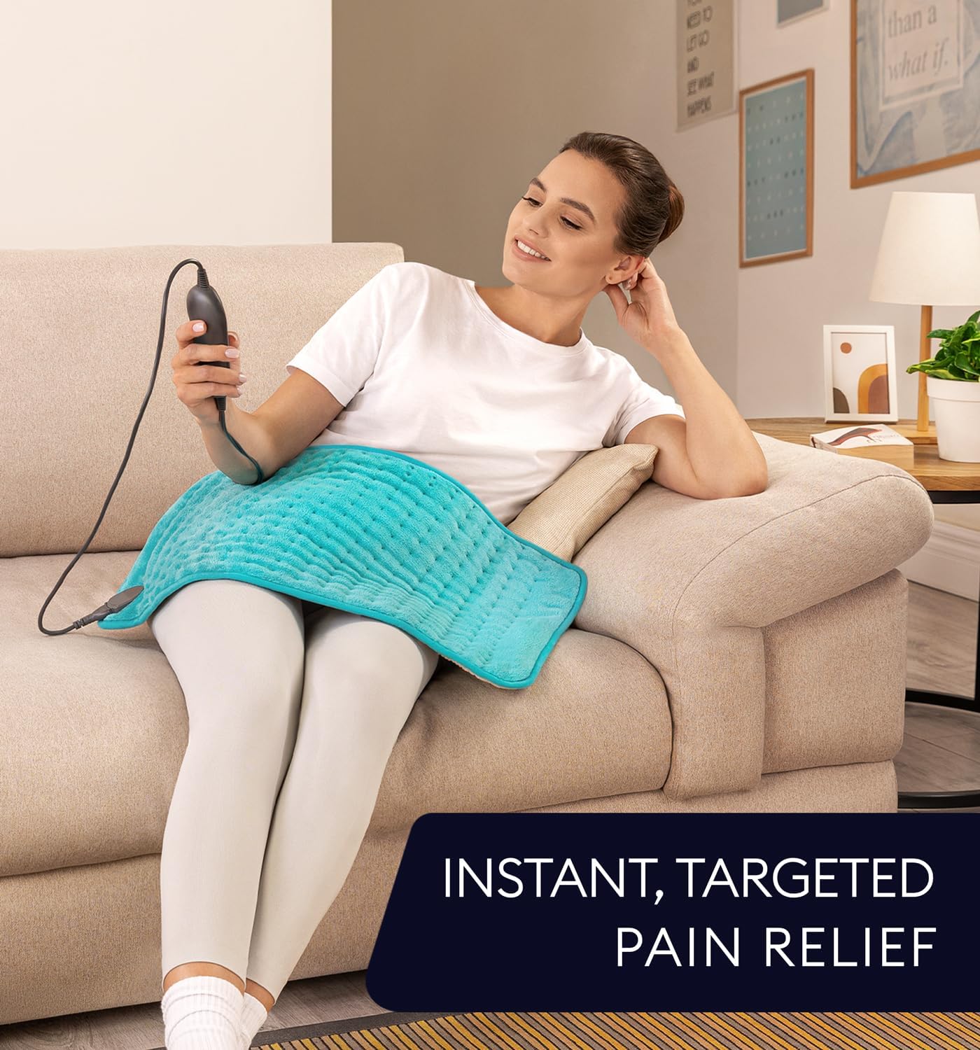 Viridian green heating pad on couch for targeted relief, cord plugged in
