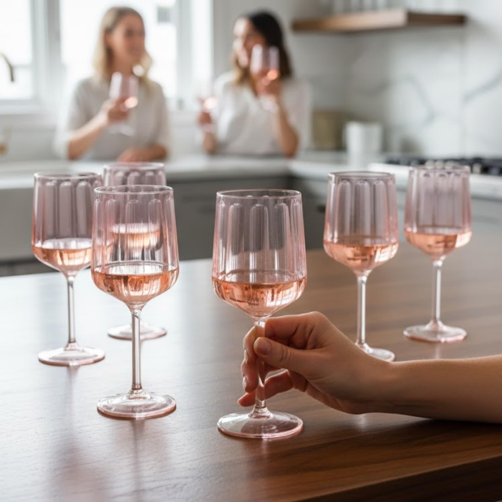 Pink acrylic stemmed goblet with ribbed cup and flared base, hand holding one