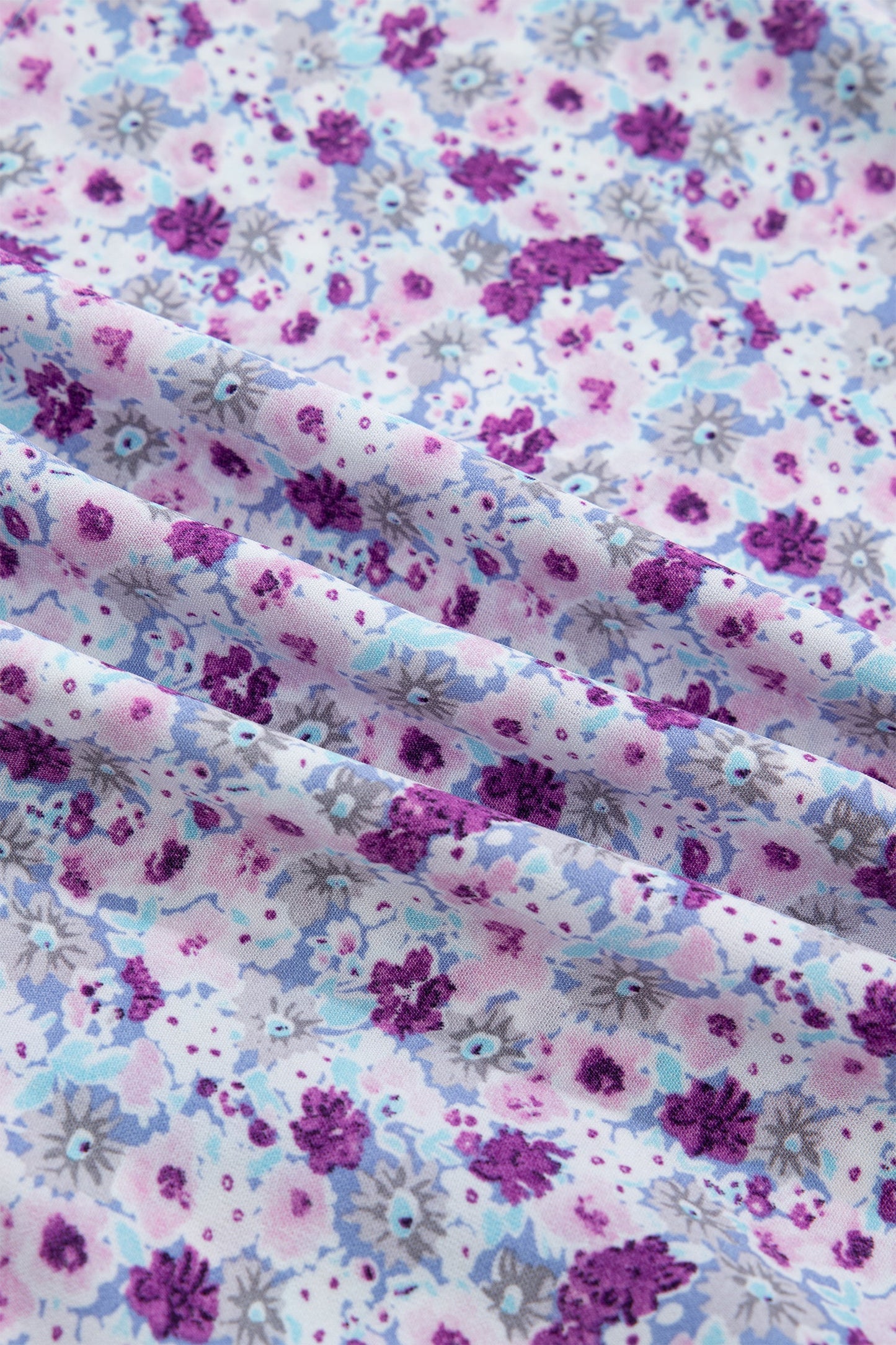 Close-up of purple and blue floral print fabric with gathered texture