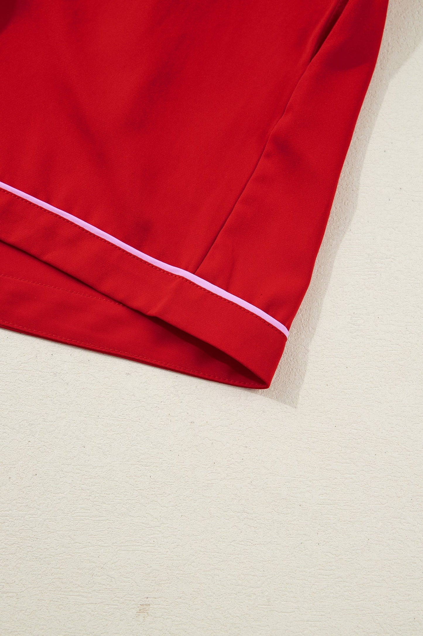 Red pajama shorts hem with white piping and stitched edge