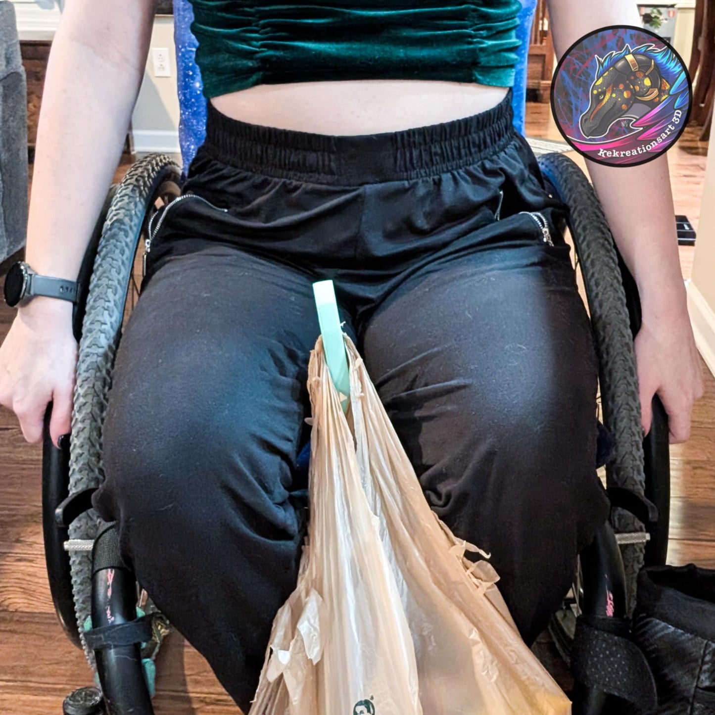 Teal wheelchair grocery bag hook holding a shopping bag on the side