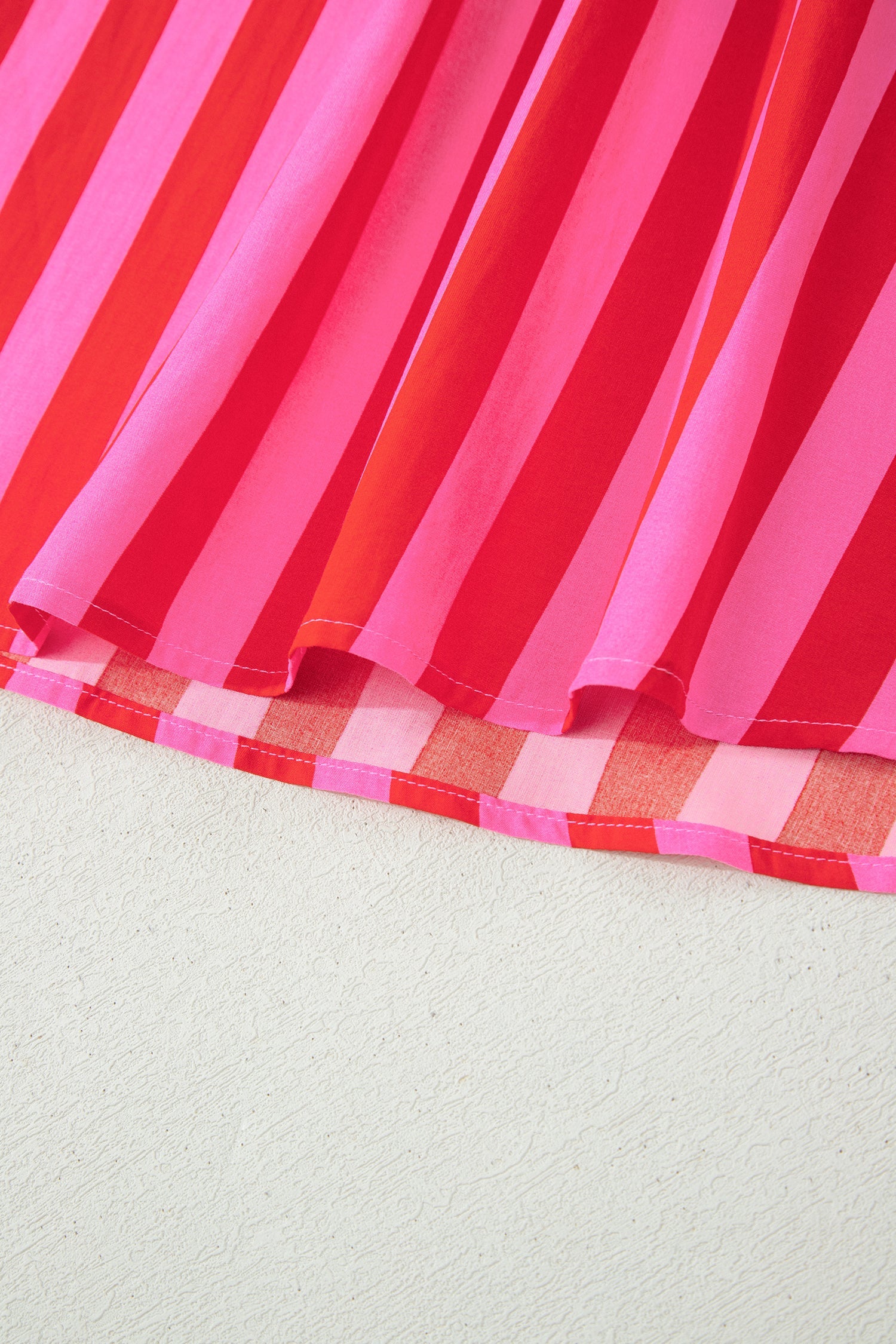 Pink and red striped mini dress hem with red check trim