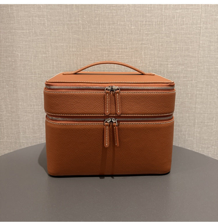 Brown leather-look jewelry storage tote, front view, with double zippers and handle