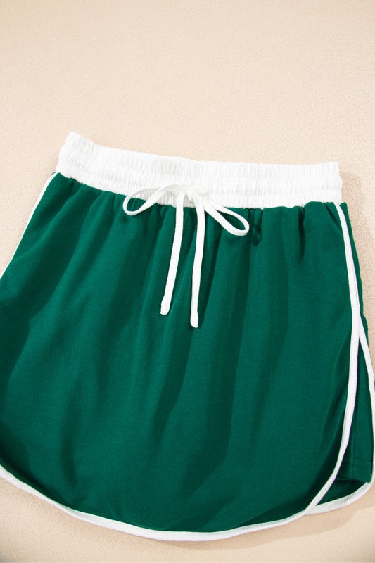 Green mini skirt with elastic waistband and white drawstring ties
