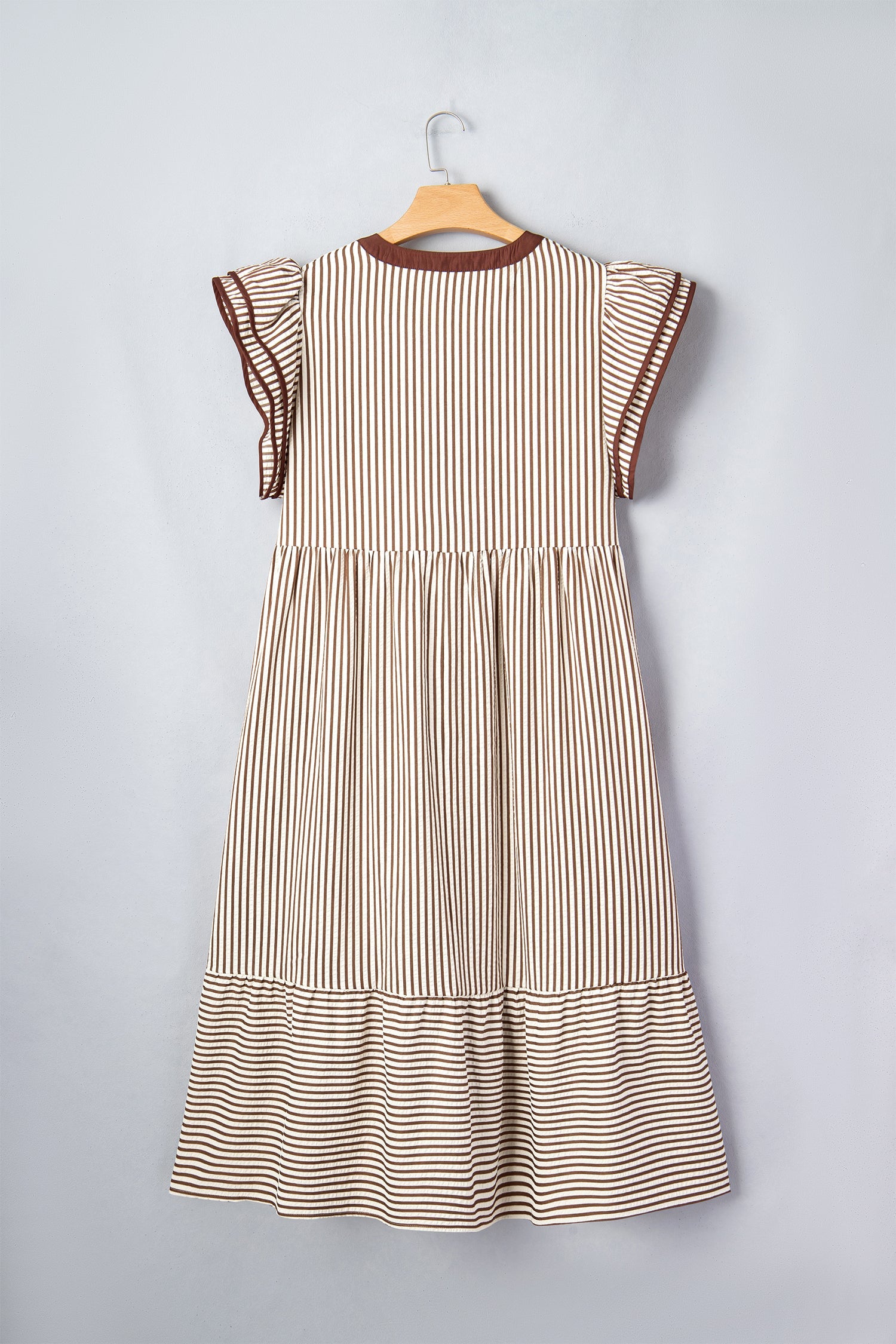 Striped maxi dress on hanger with flutter sleeves and tiered skirt, brown trim neckline