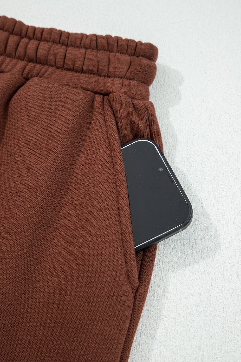 Elastic waistband and drawstring detail on coffee-brown solid pants