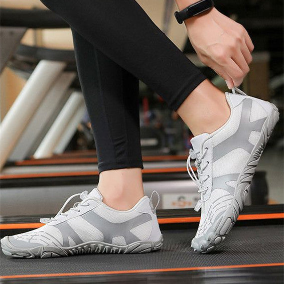 White hiking shoes with lace-up front and grippy tread sole, worn by person walking